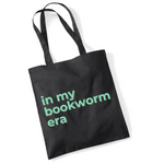 Load image into Gallery viewer, Black tote bag with 'in my bookworm era' text in green on a white background