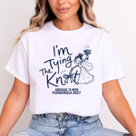 Load image into Gallery viewer, A woman wearing a white graphic t-shirt with the text 'I'm Tying The Knot' and 'ABIGAIL'S HEN FUENGIROLA 2027' printed in navy blue, paired with light-wash blue jeans.