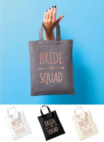 Load image into Gallery viewer, Grey Bride Squad mini tote bag with rose gold text held up, with white, black and natural bag options