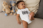 Load image into Gallery viewer, Baby wearing a white New To The Cousin Crew bodysuit with black print