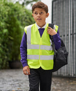 Load image into Gallery viewer, Boy wearing a yellow kids hi vis vest with a school bag