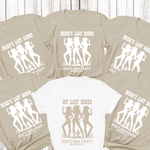 Load image into Gallery viewer, Beige t-shirts with white graphic designs and text on a wooden surface
