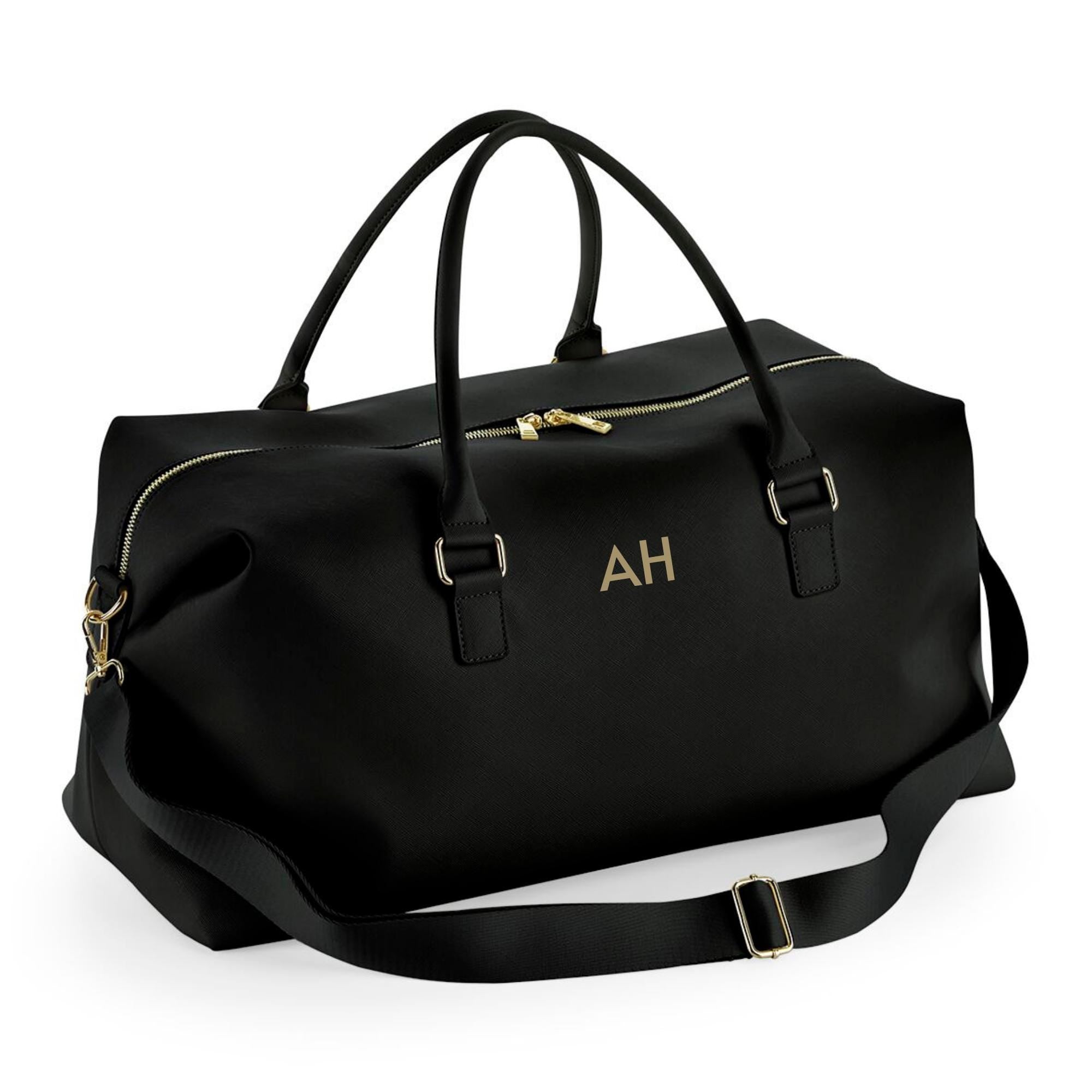 A black leather duffel bag with gold accents, featuring two handles and a zipper closure.