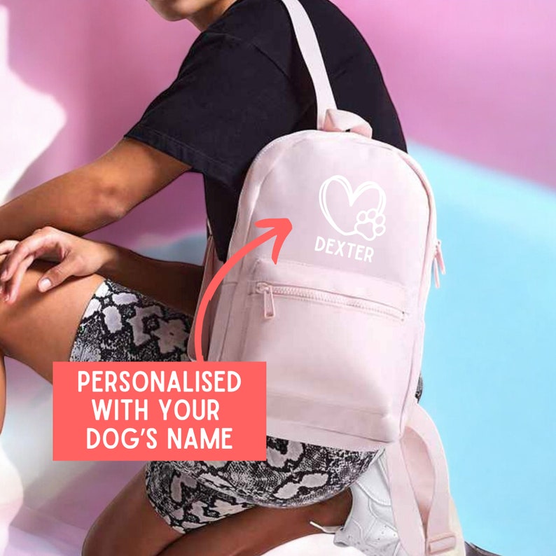 a woman sitting on a bed with a pink backpack