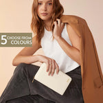 Load image into Gallery viewer, A woman with long brown hair is sitting and holding a white wallet with a gold zipper. She is wearing a white top and a brown jacket.
