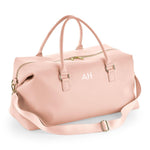 Load image into Gallery viewer, A pink leather duffel bag with a gold zipper and handles, featuring a personalized monogrammed logo on the front.
