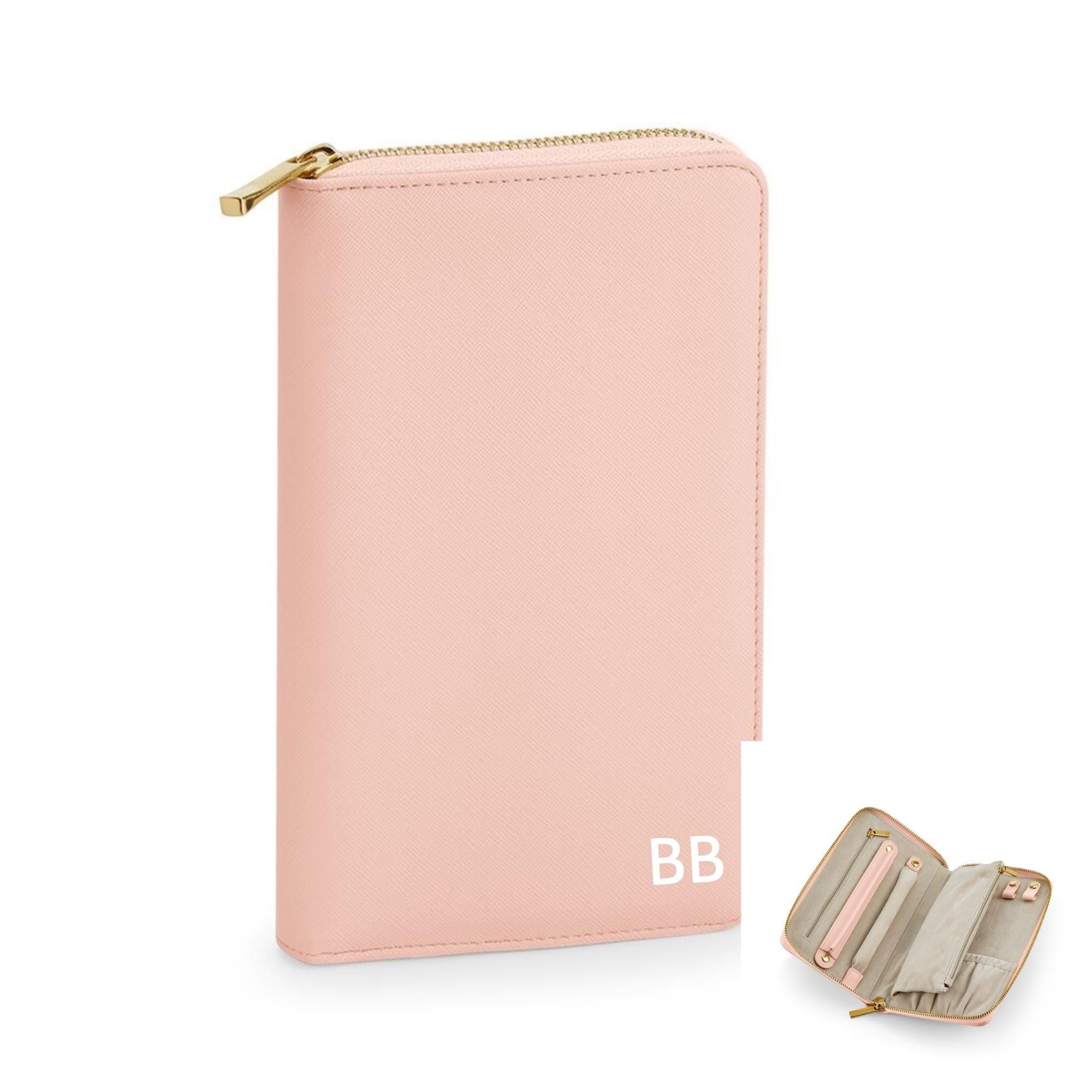 A pink wallet with a zipper closure and a small compartment, featuring a personalized monogram.