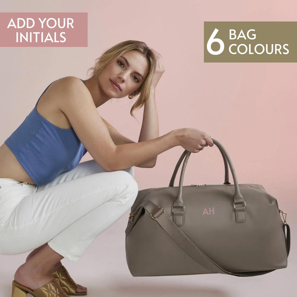 A woman in a blue top and white pants is posing with a gray duffel bag, accompanied by text promoting the addition of initials to bags.