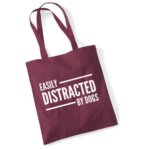 a red bag that says easily distracted by dogs