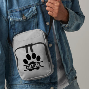 a person wearing a jean jacket holding a white bag with a dog paw on it