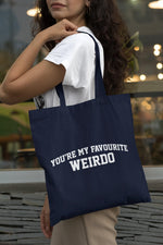 Load image into Gallery viewer, Woman carrying a navy You're My Favourite Weirdo cotton tote bag over her shoulder
