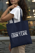 Load image into Gallery viewer, Woman carrying a navy I Would Like To Confirm That I Don't Care cotton tote bag over her shoulder
